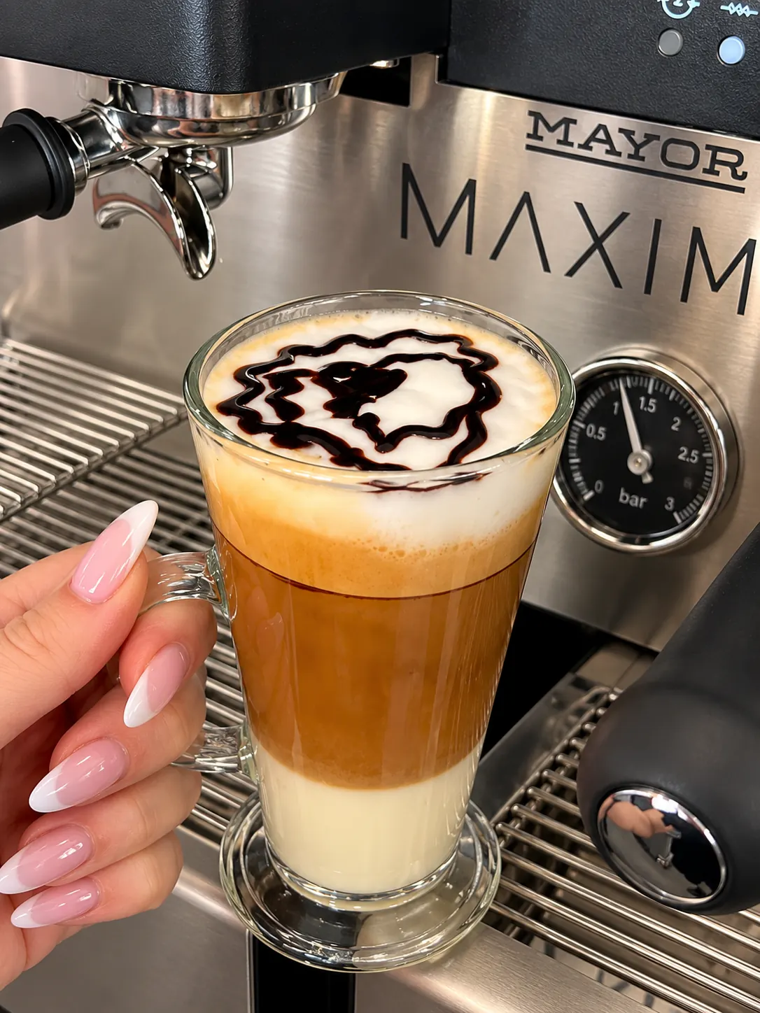 Café bombón en vaso: leche condensada, café y espuma con sirope de chocolate