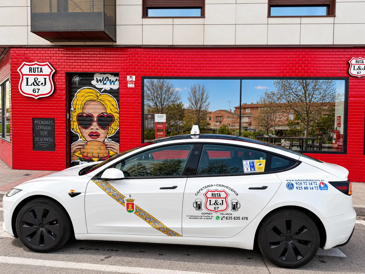 Fachada roja con el mural pop-art y un taxi con el logotipo de Ruta 67